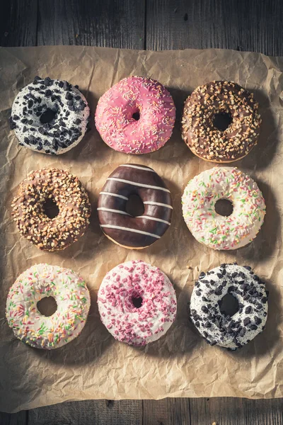 Sweet and fresh donuts on baking paper — Stock Photo, Image