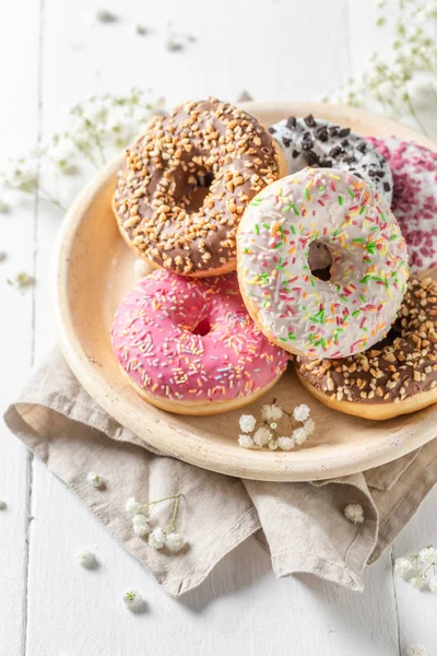 Donuts caseiros com vários tipos de coberturas na placa branca — Fotografia de Stock