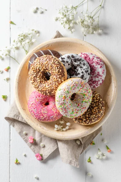Donuts doces com vários tipos de coberturas na placa branca — Fotografia de Stock