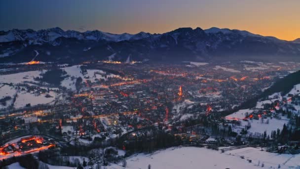 Luchtfoto van prachtige schemering over besneeuwde zakopane in de winter — Stockvideo