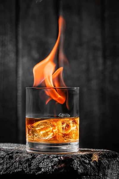Vlammen Een Glas Met Whisky Zwart Verbrand Hout — Stockfoto