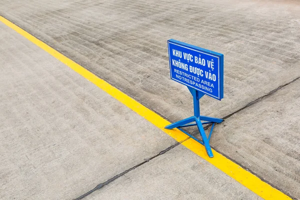 Blue sign for restricted area behind a yellow line — Stock Photo, Image