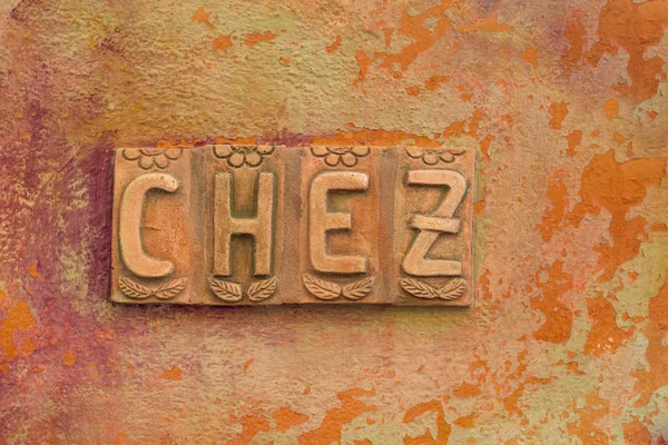 Buchstaben "chez" an einer orangefarbenen Wand — Stockfoto