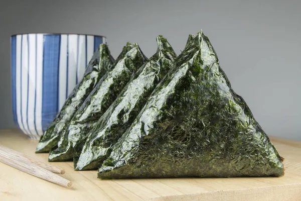 Ιαπωνικά τρόφιμα, μπάλα ρύζι (onigiri) με το πράσινο τσάι στο γαλάζιο Κύπελλο — Φωτογραφία Αρχείου