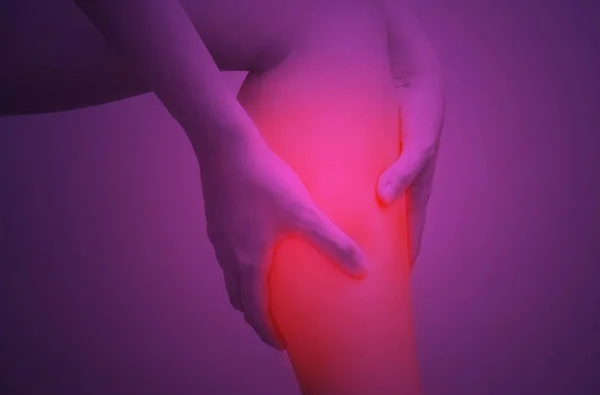 Junge Frau hält ihren Wadenmuskel vor Schmerzen mit rot hervorgehobenem, isoliertem Hintergrund auf weißem Hintergrund — Stockfoto
