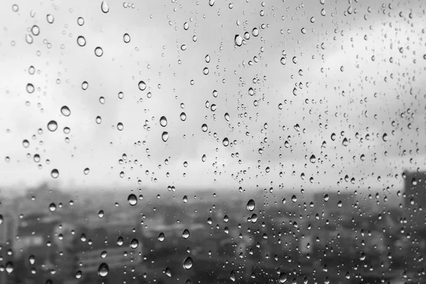 Капли сильного дождя на стекле с облачным фоном — стоковое фото
