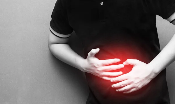 Karın ağrısı ve yaralanma göbek alan üzerinde sahip bir genç adam. Tıbbi sağlık kavramı