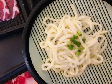 Udon Japon şehriye ahşap mat shabu için taze dilimlenmiş domuz ile