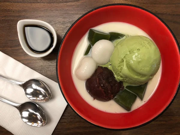 Yeşil çay matcha dondurma kaşık kuru fasulye mochi ve kırmızı kase, Japon geleneksel tatlı süt ile Üstten Görünüm
