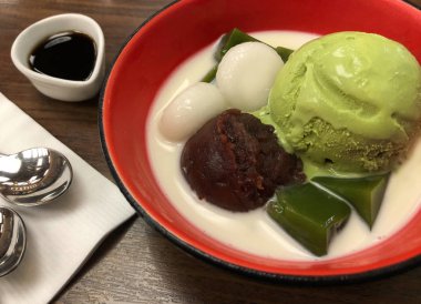 Yeşil çay matcha dondurma kaşık kuru fasulye mochi ve kırmızı kase, Japon geleneksel tatlı süt ile Üstten Görünüm