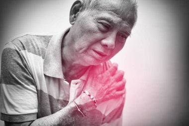 Elderly Asian man put his hand on his shoulder because of shoulder pain or muscle pain. Black and white tone with red spot on his shoulder. Healthcare and Medical concept clipart