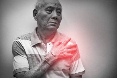 Elderly Asian man put his hand on his shoulder because of shoulder pain or muscle pain. Black and white tone with red spot on his shoulder. Healthcare and Medical concept clipart