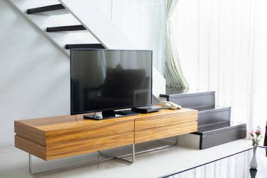 Modern oturma odasındaki ahşap dolapta akıllı TV geniş ekran standı. Daha az kavramı daha çok iç tasarımdır.