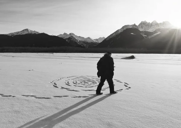 Homem fazendo círculos de neve ao pôr do sol — Fotografia de Stock