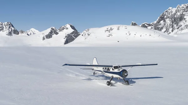 Klein vliegtuig landing op sneeuw in de bergen van Alaska — Stockfoto