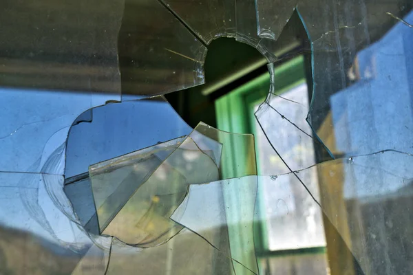 Ventana de vidrio rota con un agujero de bala — Foto de Stock