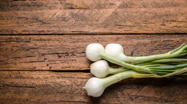 Tahta masada taze organik arpacık soğanları.