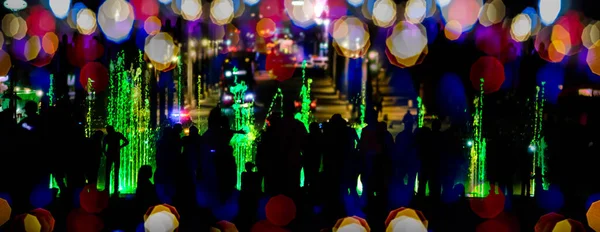 Силуэты Людей Идущих Играющих Красочном Освещенном Фонтане Ночью — стоковое фото