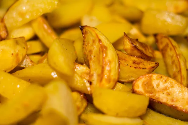 Potato slices are baked on a baking sheet.