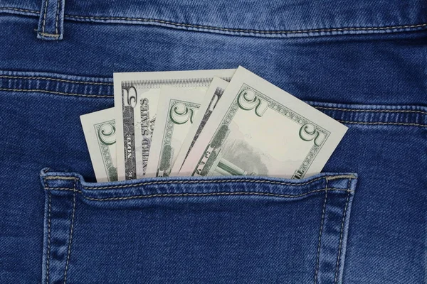 Five dollars bill sticking out of the blue jeans pocket