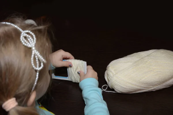 Adorable little girl knitting a vintage style woolen hat