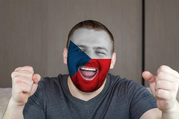 Face of young screaming  man painted with flag of Czech.  Soccer team fan.