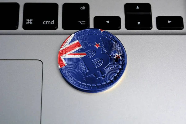 Bitcoin on keyboard background, the flag of new Zealand is shown on bitcoin