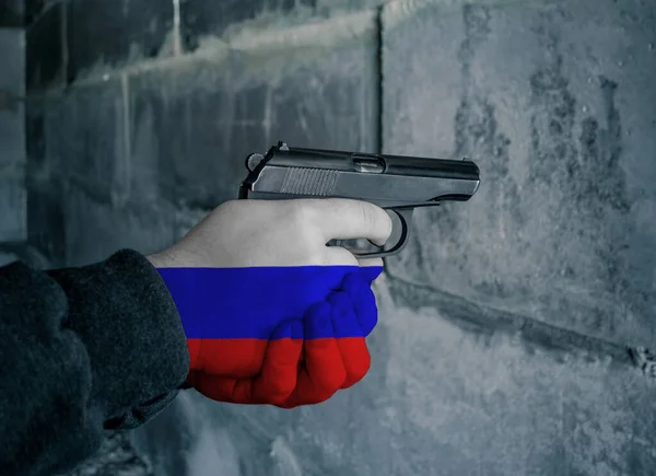 The flag of Russia is on the hand holding the gun. Military concept
