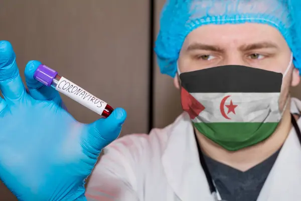 Doctor wearing mask with flag Western Sahara holding blood test for Coronavirus