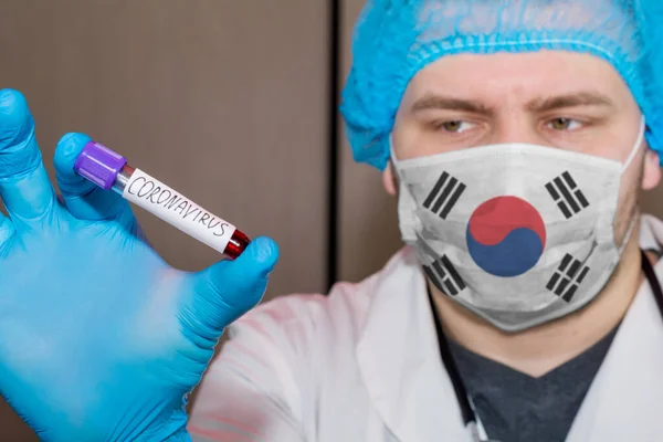 Doctor wearing mask with flag South Korea holding a blood test the Coronavirus