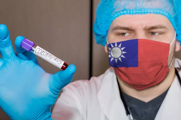 Doctor wearing mask with flag Taiwan holding a blood test for the Coronavirus