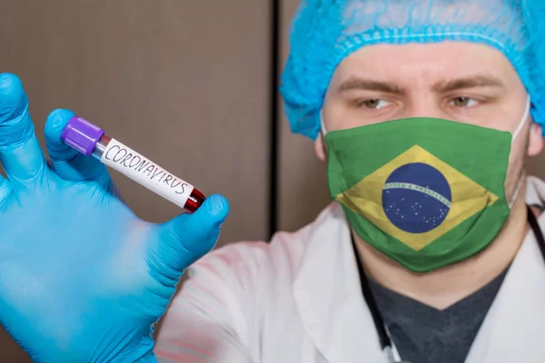 Doctor wearing mask with flag Brazil holding a blood test for the Coronavirus