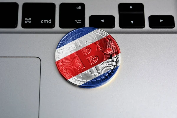 Bitcoin on keyboard background, the flag of Costa Rica is shown on bitcoin