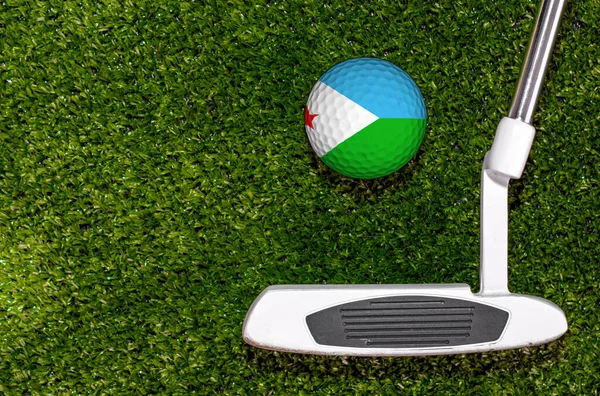 A golf club and a ball with flag Djibouti during a golf game