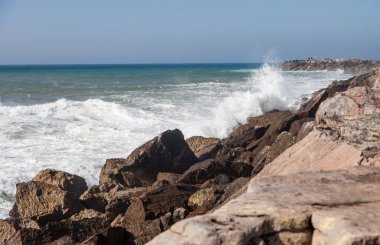 Okyanus dalgaları kayalara çarpıyor.
