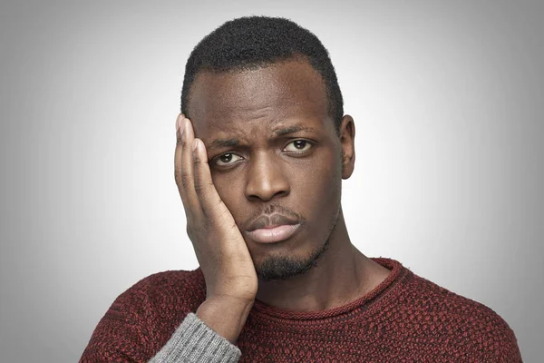 Tand pijn concept. Indoor headshot van jonge African American mannelijke gevoel pijn, zijn wang met de hand te houden. Zwarte man lijdt aan slechte kiespijn, op zoek naar camera met pijnlijke expressie. — Stockfoto