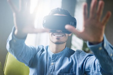 Genç çekici Avrupa erkek yakalama atış havada bir şey kapatmak, mobil oyun uygulamaları için yenilikçi sanal gerçeklik kulaklık oynamak. Mobil Oyunlar apps ile yenilikçi 3d gözlük kullanma 