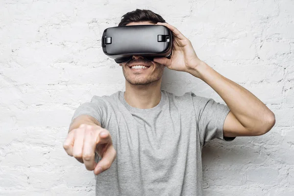 Sanki bir şey ile etkileşim onun parmakları işaret 3d gözlük, yakışıklı Beyaz delikanlı. Çekici adam Vr kulaklık kullanarak video oyunu oynarken sanal gerçeklik yaşandığı gülümseyen