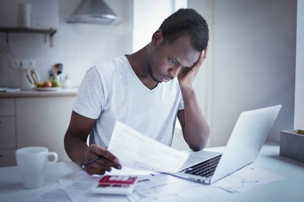 Young benadrukt Afro-Amerikaanse man hebben geen geld om te betalen schulden en huur voor appartement, hoofd houden in wanhoop, niet van rekeningen betalen kan, met financiële troules. Planning concept van de huishoudelijke begroting — Stockfoto