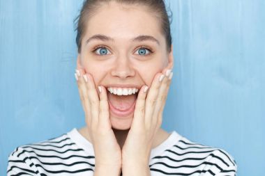 Oh ile erkek portresi kadar Tanrım, Wow duygu ifade kapatın. Dinleme cihazı mavi gözlü genç kız yanaklarda hayretle yaygın açık ağız ile elele gülümseyen hoş sürpriz 