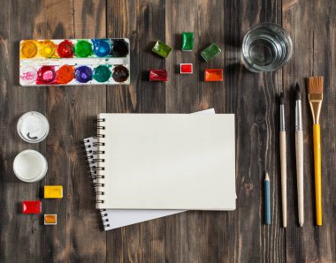 Kadar alay et. Yaratıcı alan. Koyu ahşap masa sanatsal çalışma araçları: sulu boya, Boya fırçaları ve su