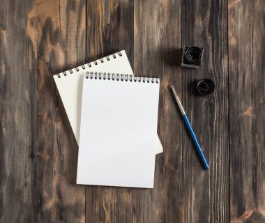 Kadar alay et. Tükenmez kalem ve defter. Yaratıcı alan. Koyu ahşap masa sanatsal çalışma araçları