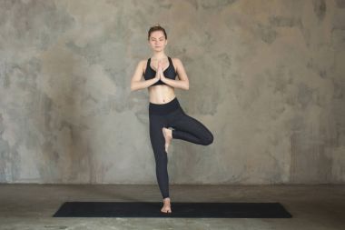 Namaste tekstüre duvara / kentsel içinde eller genç kadın pratik Yoga ağaç, Vrikshasana poz, arka plan 