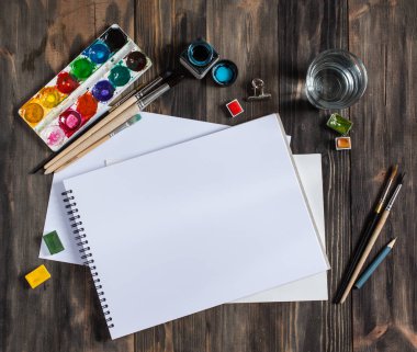 Kadar alay et. Yaratıcı alan. Koyu ahşap masa sanatsal çalışma araçları: sulu boya, Boya fırçaları ve su