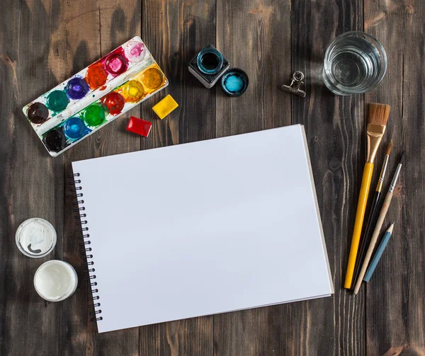 Kadar alay et. Yaratıcı alan. Koyu ahşap masa sanatsal çalışma araçları: sulu boya, Boya fırçaları ve su