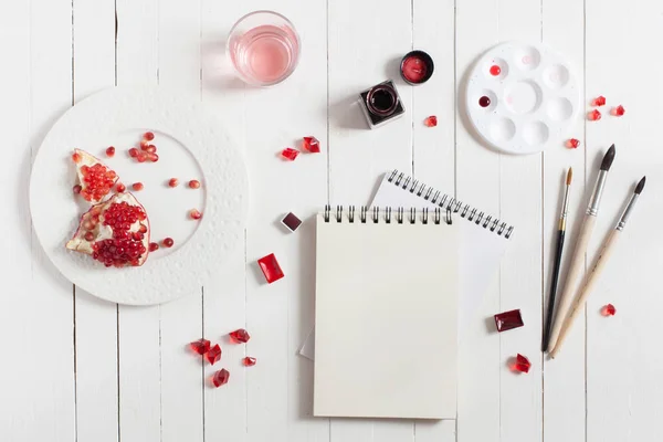 Mock up. Artist workspace on white wooden table: red watercolor, paintbrushes and water — Stock Photo, Image