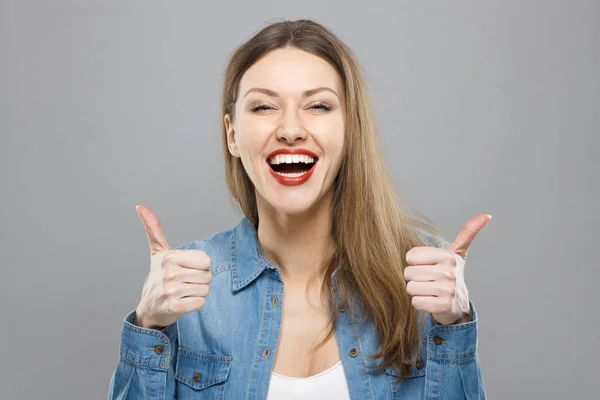 Close-up de jovem otimista feminino isolado em fundo cinza mostrando colisões com emoções positivas de conteúdo e felicidade. Copyspace, conceito de satisfação com a qualidade e recomendação . — Fotografia de Stock