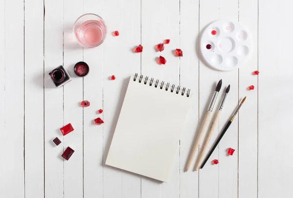 Vysmívat se. Pracovní prostor umělec na bílý dřevěný stůl: červená akvarel, — Stock fotografie