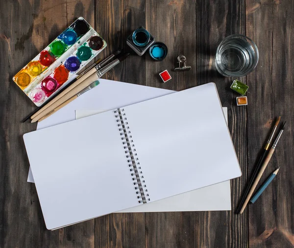 Kadar alay et. Yaratıcı alan. Koyu ahşap masa sanatsal çalışma araçları: sulu boya, Boya fırçaları ve su