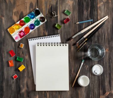 Kadar alay et. Yaratıcı alan. Koyu ahşap masa sanatsal çalışma araçları: sulu boya, Boya fırçaları ve su